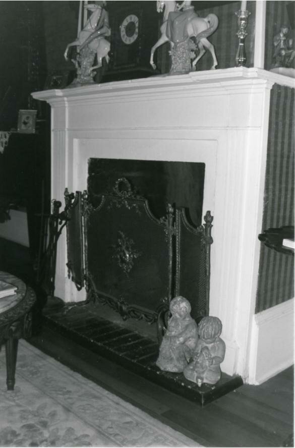 Styled console table or fireplace mantel with vintage frame, decorative plate, and aged metal object