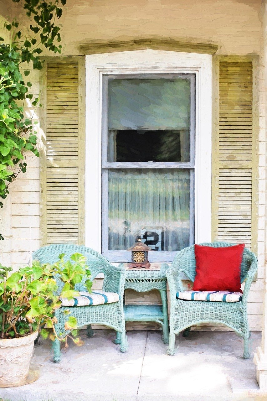 Wicker sofa or chairs in a sunroom, styled with neutral performance-fabric cushions