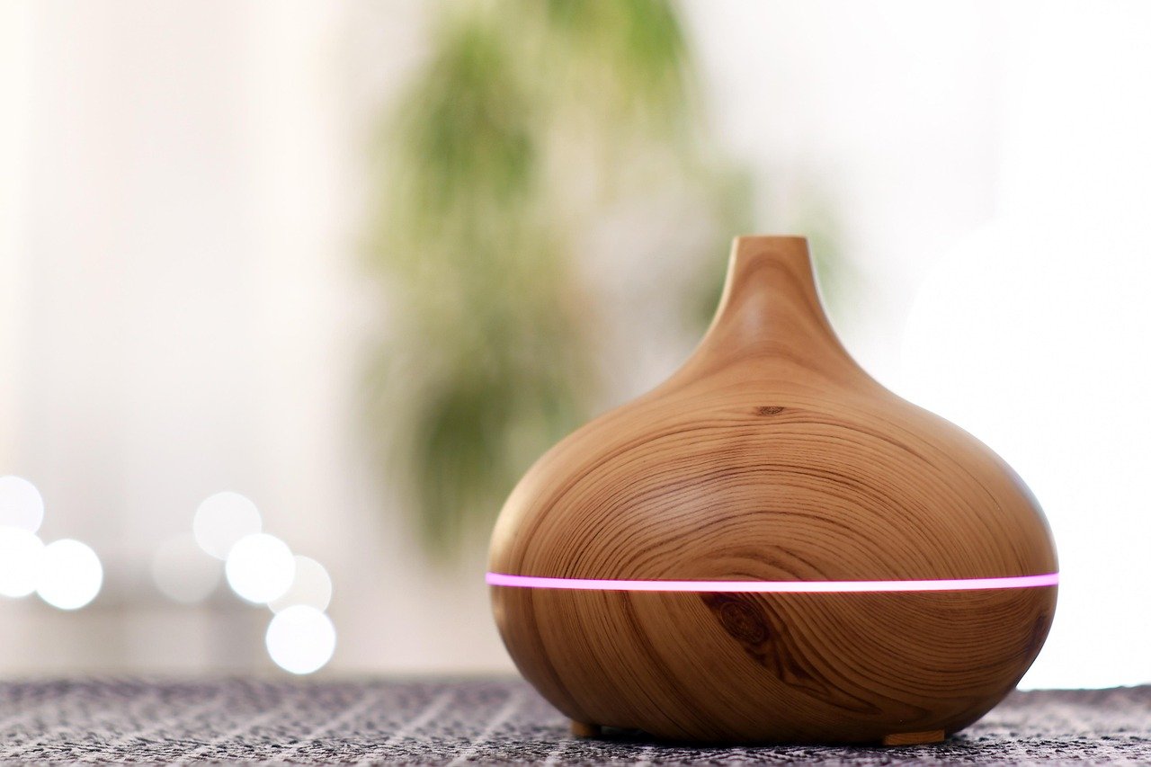 Essential oil diffuser releasing mist on a bathroom counter
