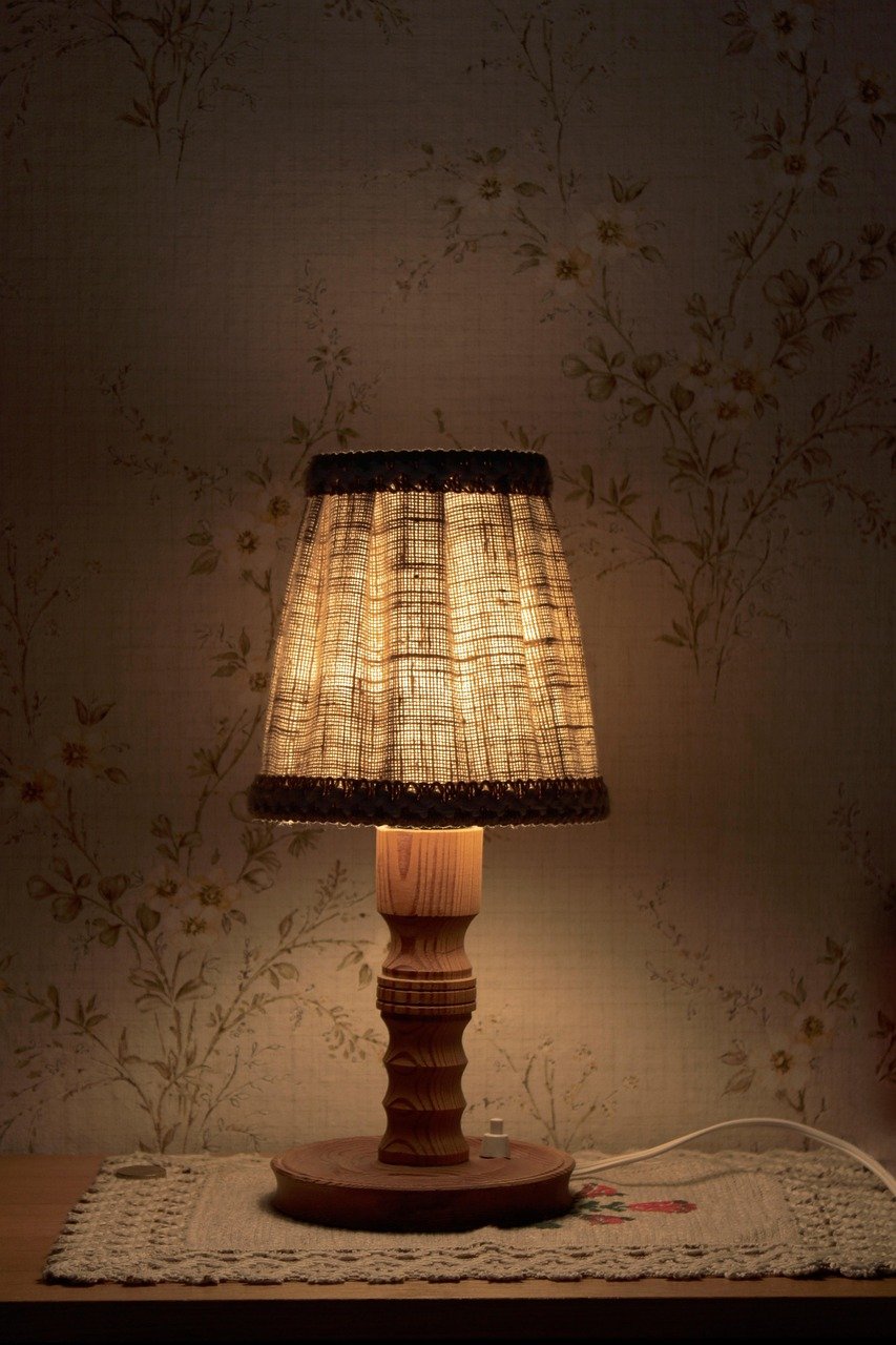 Nightstand lamp glowing warm amber light at dusk