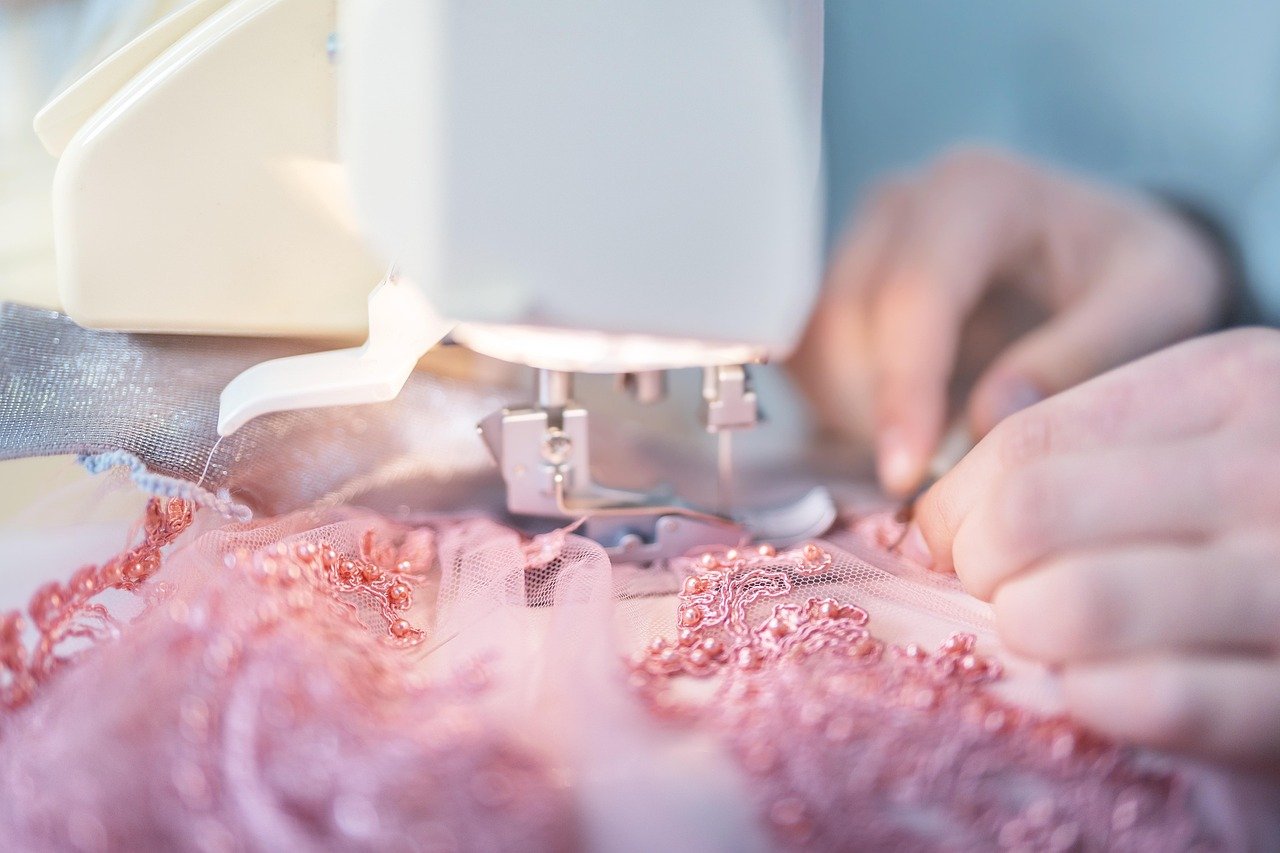 Hands sewing fabric on a table