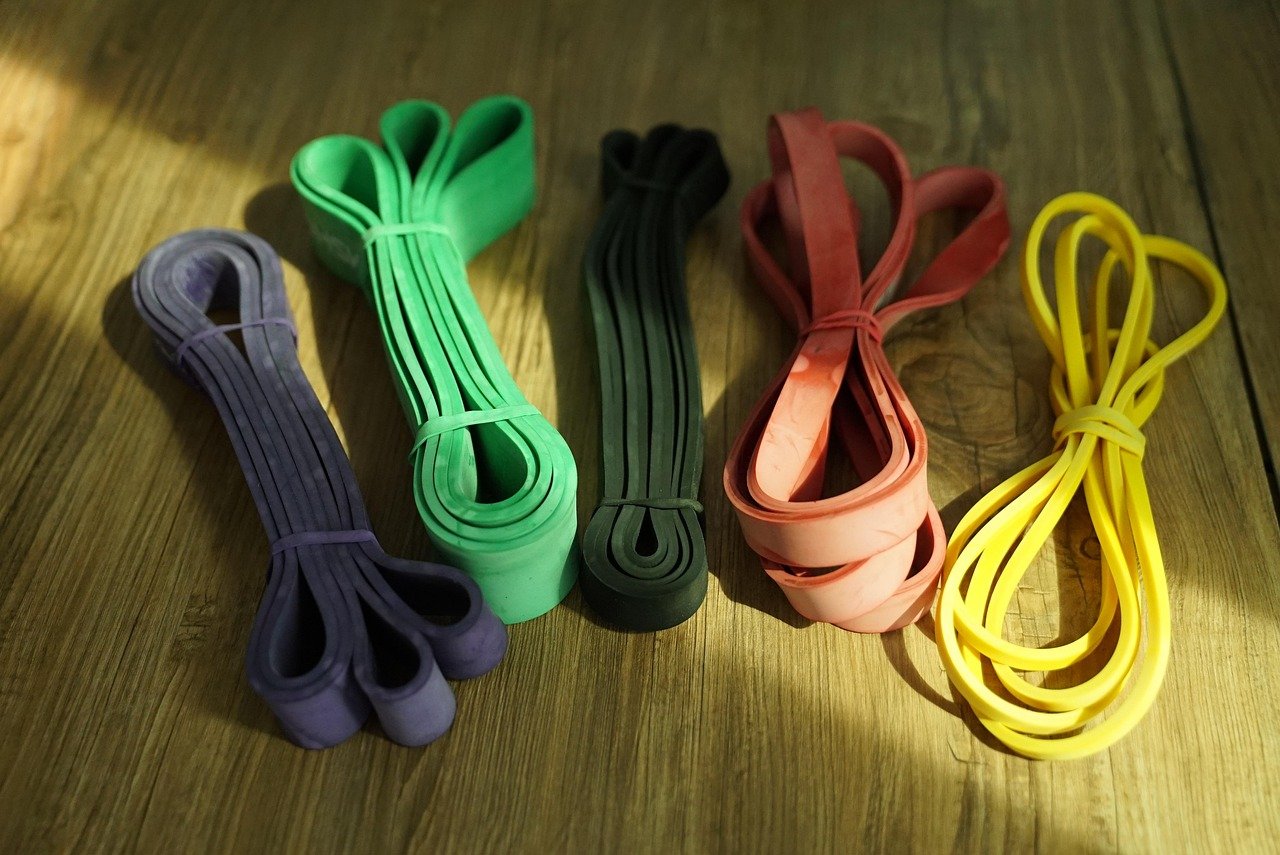 faixas de resistência de tecido em cores variadas, dobradas e guardadas em uma cesta de vime pequena, ou penduradas em um gancho de parede decorativo