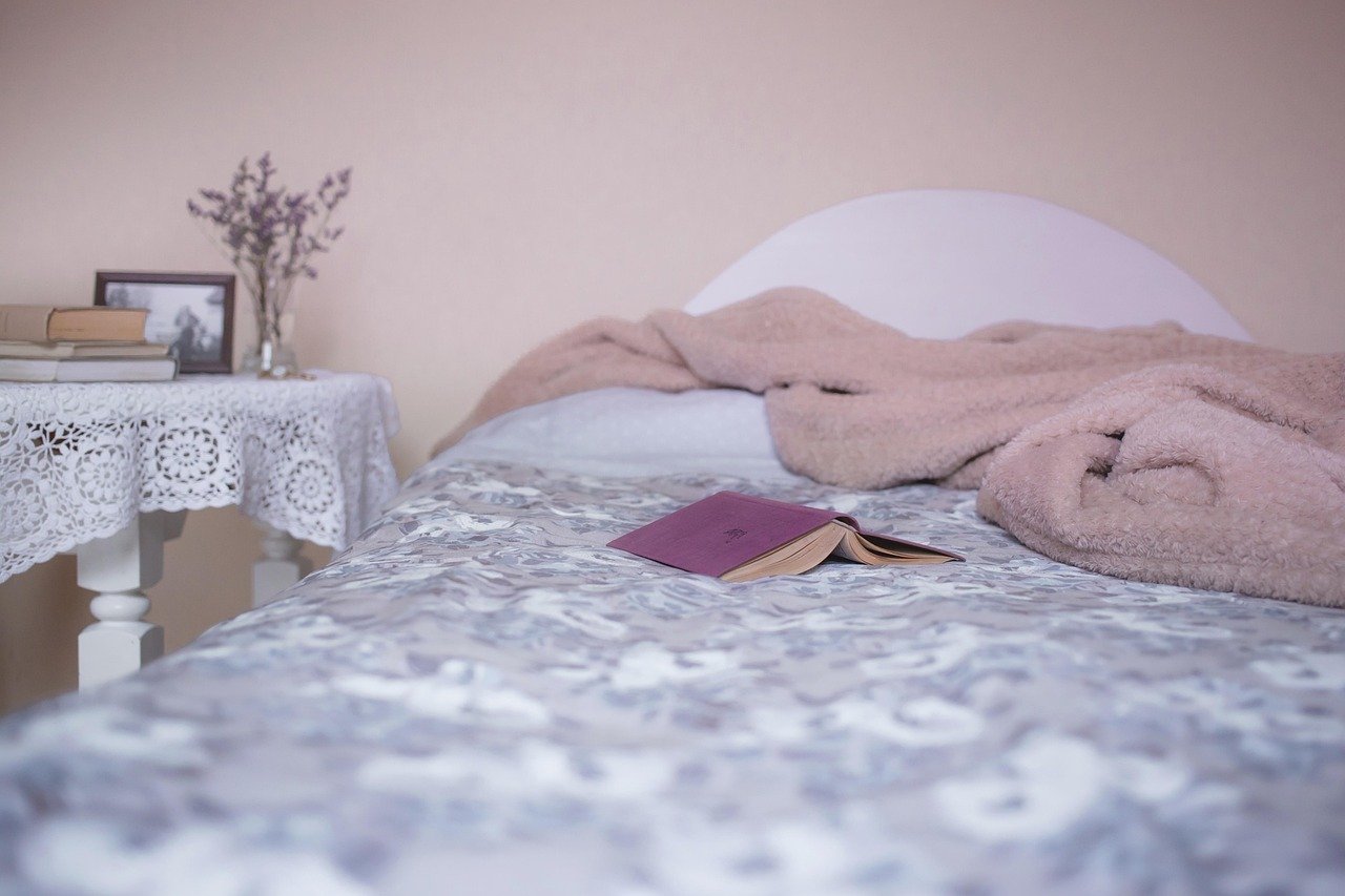 Weighted blanket folded at the foot of a made bed