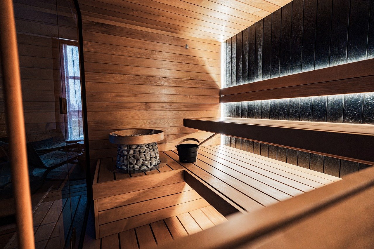 Compact wood-paneled home sauna with warm lighting