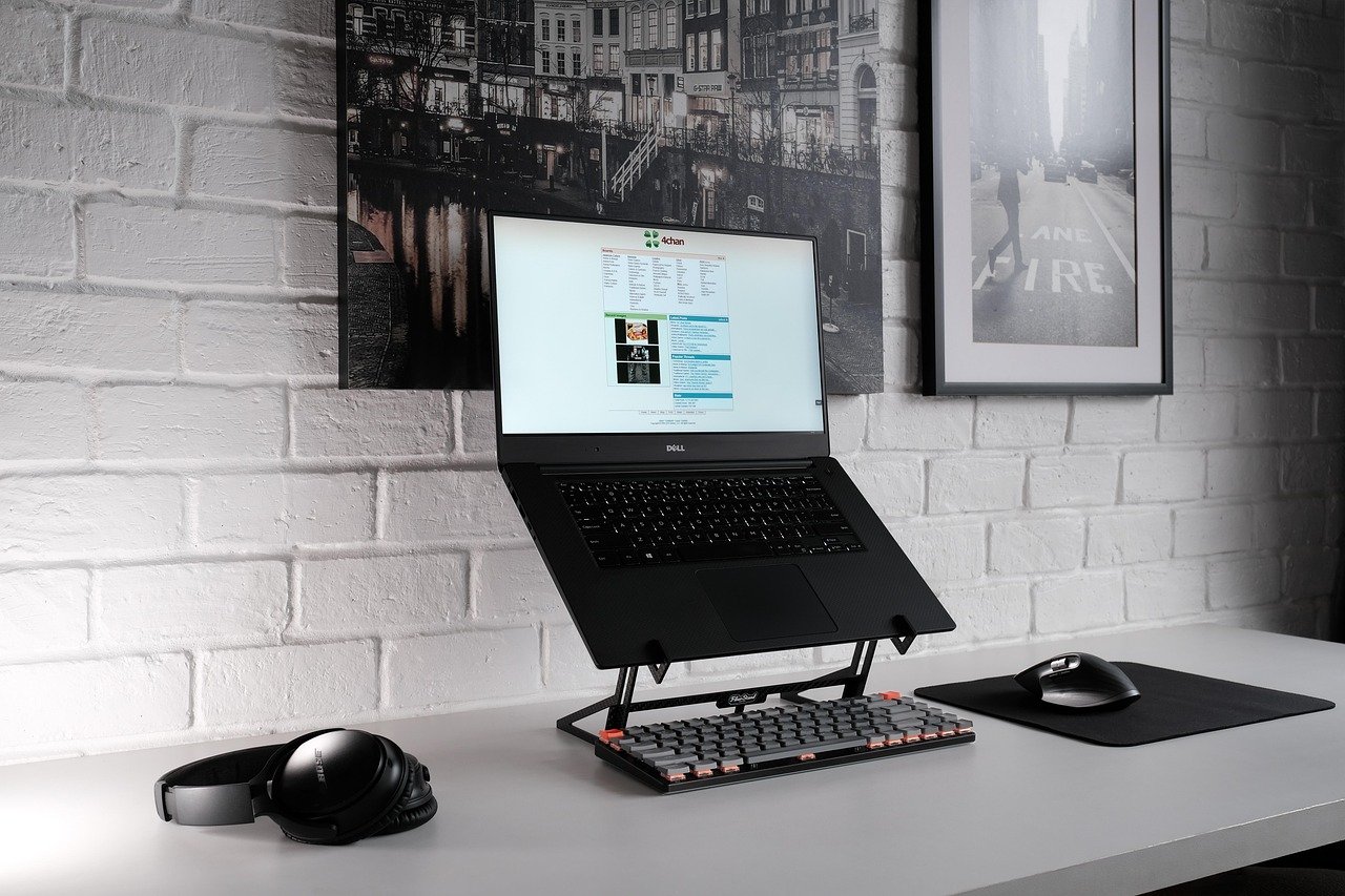 Folding aluminum laptop stand raising screen to eye level on a desk