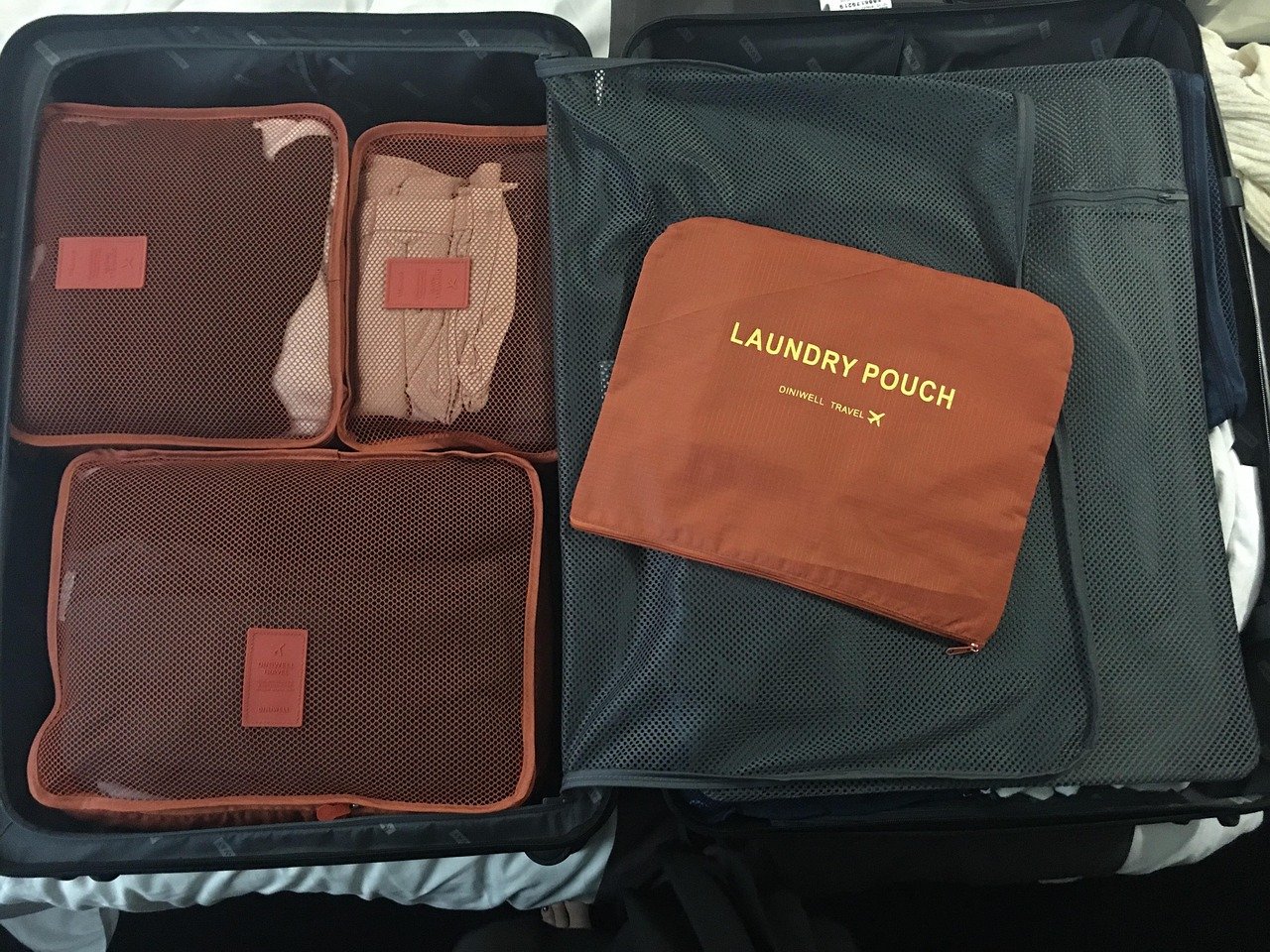 close-up de cubos de compressão de viagem organizados dentro de uma mala, roupas dobradas visíveis dentro de cada cubo