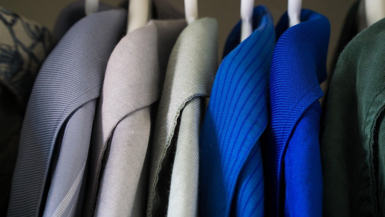 closet ou quarto de casa organizado com prateleiras modulares em cubo, caixas etiquetadas e roupas de estação dobradas, mostrando uma alternativa doméstica ao self-storage