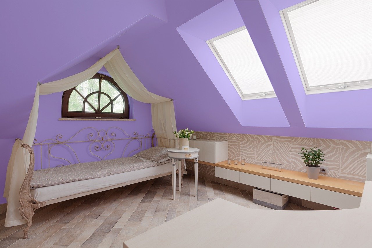 Bedroom with a plum accent wall behind the bed
