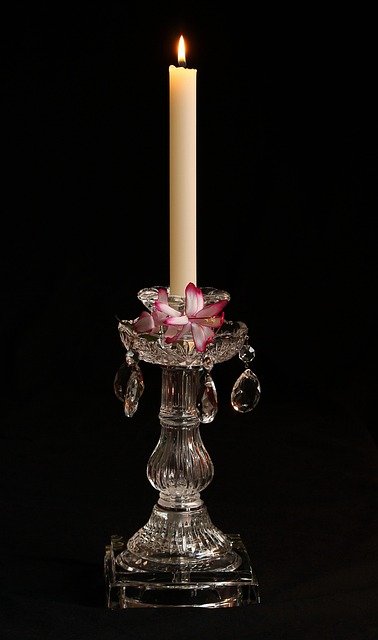 Dark wood side table with brass candlestick and antique book