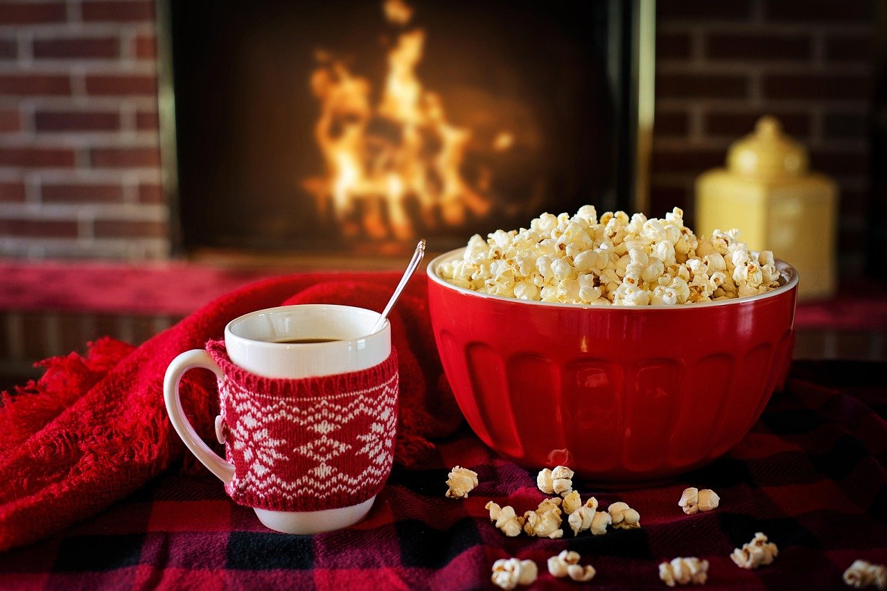 Cozy Christmas fireplace scene with a mug and popcorn