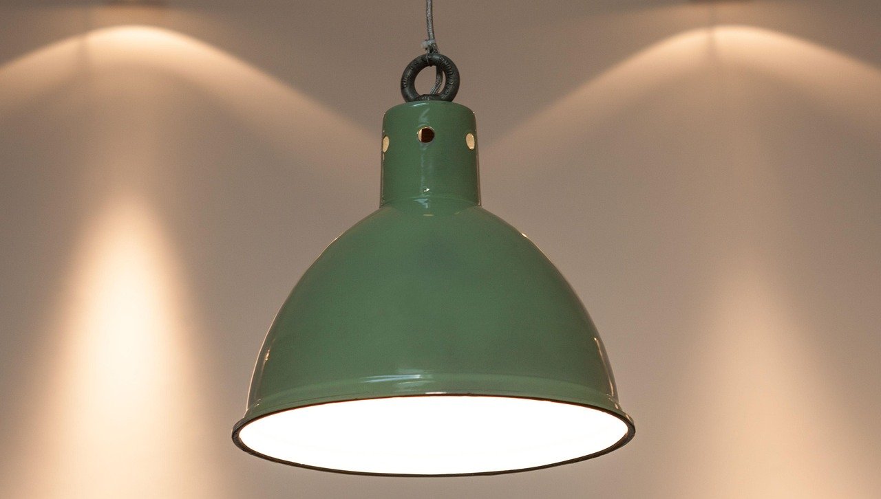 Green pendant light hanging over a kitchen table