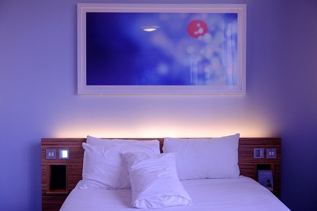 Large upholstered headboard with warm neutral bedding